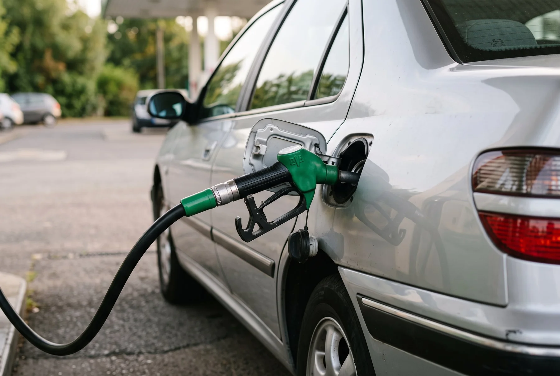 Pistolet de carburant vert près d’une trappe de réservoir.